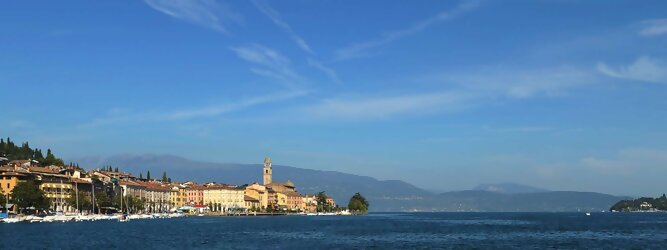 Trip Slowakei beliebte Urlaubsziele am Gardasee -  Mit einer Fläche von 370 km² ist der Gardasee der größte See Italiens. Es liegt am Fuße der Alpen und erstreckt sich über drei Staaten: Lombardei, Venetien und Trentino. Die maximale Tiefe des Sees beträgt 346 m, er hat eine längliche Form und sein nördliches Ende ist sehr schmal. Dort ist der See von den Bergen der Gruppo di Baldo umgeben. Du trittst aus deinem gemütlichen Hotelzimmer und es begrüßt dich die warme italienische Sonne. Du blickst auf den atemberaubenden Gardasee, der in zahlreichen Blautönen schimmert - von tiefem Dunkelblau bis zu funkelndem Türkis. Majestätische Berge umgeben dich, während die Brise sanft deine Haut streichelt und der Duft von blühenden Zitronenbäumen deine Nase kitzelt. Du schlenderst die malerischen, engen Gassen entlang, vorbei an farbenfrohen, blumengeschmückten Häusern. Vereinzelt unterbricht das fröhliche Lachen der Einheimischen die friedvolle Stille. Du fühlst dich wie in einem Traum, der nicht enden will. Jeder Schritt führt dich zu neuen Entdeckungen und Abenteuern. Du probierst die köstliche italienische Küche mit ihren frischen Zutaten und verführerischen Aromen. Die Sonne geht langsam unter und taucht den Himmel in ein leuchtendes Orange-rot - ein spektakulärer Anblick.
